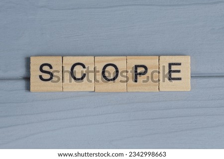 text the word scope from brown wooden small letters with black font on an gray table Royalty-Free Stock Photo #2342998663