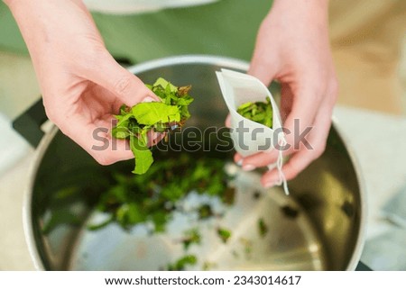 The process of packing the collection of tea herbs in convenient portioned bags. Storage of aromatic herbs collected in the garden at home. Royalty-Free Stock Photo #2343014617