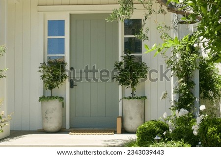 Traditional modern front door with symmetrical potted plants Royalty-Free Stock Photo #2343039443