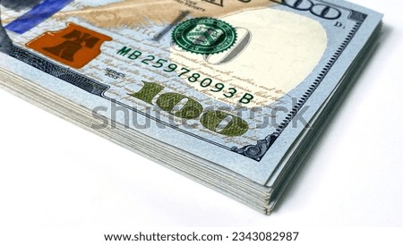 A bundle of $100 bills is lying on a white table. Close-up. Hundred-dollar bills. Economics and finance. Cash banknotes. The American national currency. Cash dollar bills.