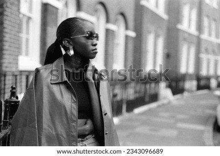 Blurry image of black female model in the street. There is a lot of analog grain. Picture taken with a film camera.
