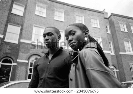 Monochrome image of two twin brother posing in a London street. Analog film classic image. Picture made with a old vintage camera.