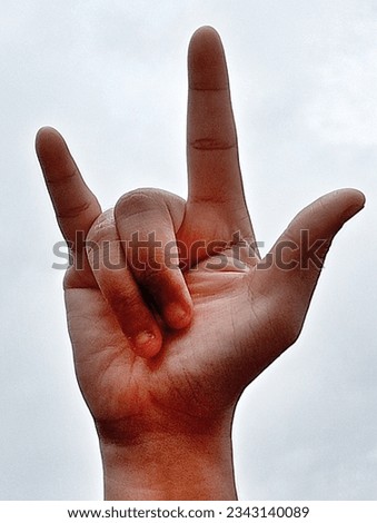 I love you hand sign, sky background.