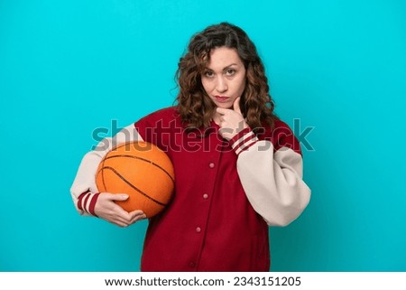 Young caucasian basketball player woman isolated on blue background thinking