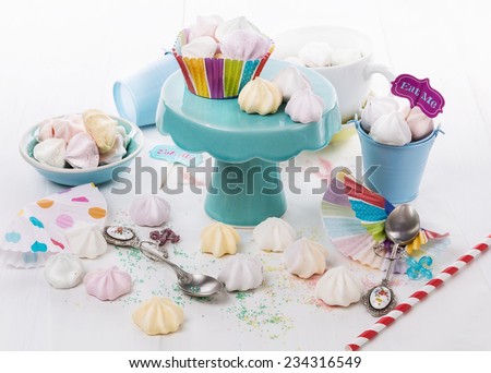 Colorful meringue drops for party over white wooden background