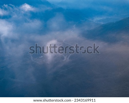 Overlook of the winding road in the mountains with blue sky and white clouds
