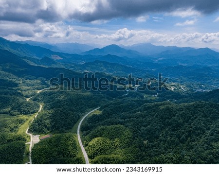 Overlook of the winding road in the mountains with blue sky and white clouds
