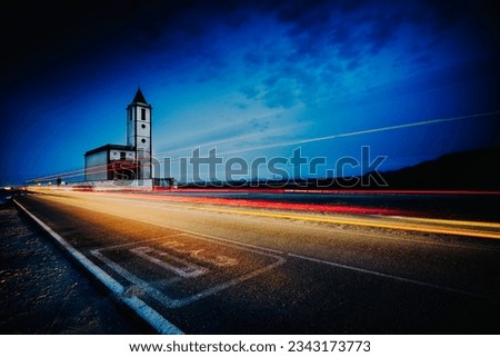 light trails at sunset next to the church of las salinas de cabo de gata and traffic signaling on the asphalt Royalty-Free Stock Photo #2343173773