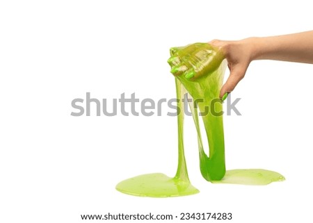 Green slime toy in woman hand with green nails isolated on a white background.  Royalty-Free Stock Photo #2343174283