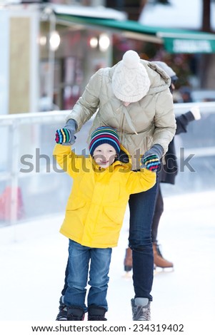 family of two having fun ice skating together at winter