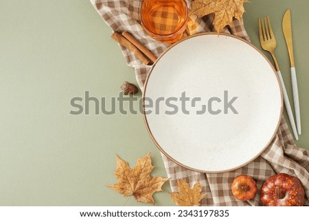 Fall-themed table setup idea. Top view photo of plate, cutlery, glass, tablecloth, autumnal decorations on olive background with empty frame for promo or text