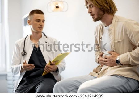Male patient on appointment with gastroenterologist at medical office. Doctor with man during medical consultation Royalty-Free Stock Photo #2343214935