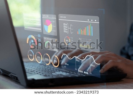 Analyst working on laptop showing business analytics data and data management system with KPIs and metrics connected to financial database. Royalty-Free Stock Photo #2343219373