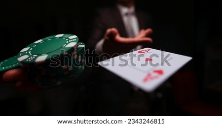 Close-up of man in presentable suit throwing playing card ace Royalty-Free Stock Photo #2343246815