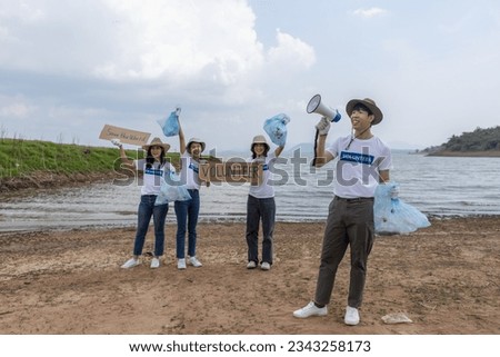 Group of volunteers holding rubbish bags and sign to campaign to save the global environment. Invitation clean up garbage in tourist attractions. Conservation and care cleanliness in nature.