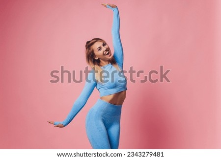 Happy fitness woman in sportwear celebrating his success over pink background. Fit and healthy woman Royalty-Free Stock Photo #2343279481