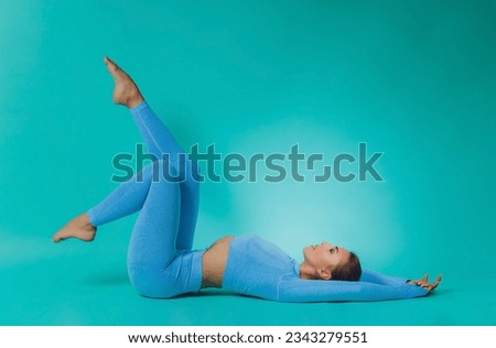 Close up of sporty young woman with muscular body on turquoise background with copy space. Sports and healthy lifestyle
