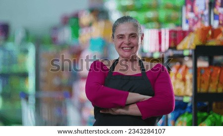 Joyful Female Grocery Store Worker Smiling at Camera with arms crossed, Wearing Apron Royalty-Free Stock Photo #2343284107
