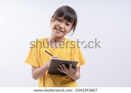 Cute little girl using tablet computer on her studio portrait on white background