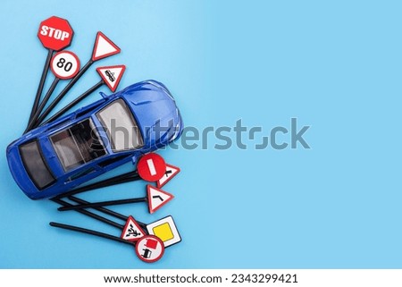 car and road signs on a blue background, copy space, necessity of car insurance and making accident claims