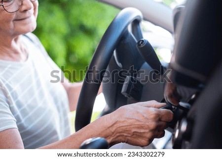 Close-up on senior woman hand in her car holding the key ready for drive and travel