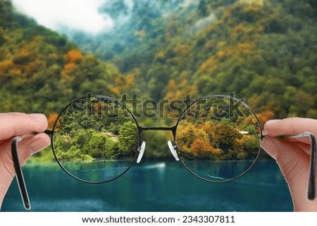 Vision correction. Woman looking through glasses and seeing landscape clearer Royalty-Free Stock Photo #2343307811