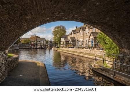 The Monmouthshire and Brecon Canal. View through a stone bridge to the rural buildings beyond, on a sunny autumn day, in Mid Wales Royalty-Free Stock Photo #2343316601