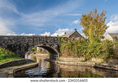 A stone bridge across the Monmouthshire and Brecon Canal. It is a sunny, autumn day in Mid Wales Royalty-Free Stock Photo #2343316603
