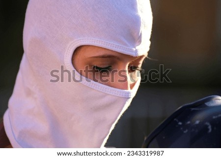 Female race car driver putting on her balaclava (Model released)