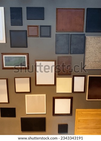 A Collection of Memories: Empty Picture Frames of Different Colors and Textures on a Gray Wall