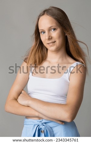 teenage girl, fourteen years old in the studio on a gray background