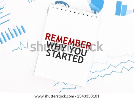White notepad with text REMEMBER WHY YOUR STARTED on the financial documentation. Finance and business concept