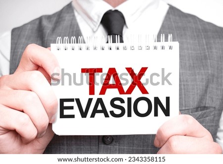 Businessman with notebook with text TAX EVASION