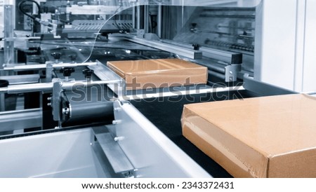 Automatic industrial machine for plastic packaging with light effect of products and food. automated packaging line with plastic film in a light blue scene. machinery product packaging concept Royalty-Free Stock Photo #2343372431