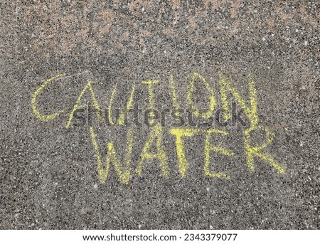 Caution sign on concrete in yellow chalk