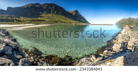 Serene turquoise lake nestled amidst rocky shores and majestic mountains.Crystal-clear water reflects blue sky above, creating tranquil and picturesque scene Royalty-Free Stock Photo #2343384841