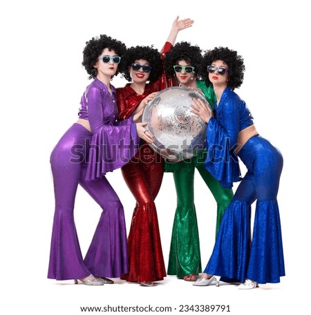 A group of girls in disco costumes are holding a disco ball and looking at the camera. Royalty-Free Stock Photo #2343389791