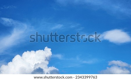 The azure sky is adorned with dramatic beautiful soft clouds, creating a mesmerizing and poetic picture. These clouds, like gentle strokes, paint a picture of serenity and awe in the vast space.
