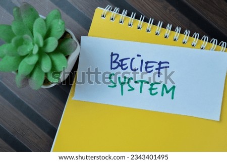 Concept of Belief System write on sticky notes isolated on Wooden Table.