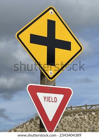 Intersection and yield sign on a post along a mountain road.