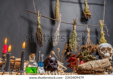 Witchcraft ceremony arranged with witch religious magic symbols. Magic items and tools. Black magic candles, ritual dry weeds, animal bones and potion vials. Halloween concept.