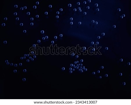 Small air bubbles underwater. Сoncept of the microworld, the distribution of micro-objects, the grouping of colonies and neural connections within artificial intelligence. Dark blue. Photo. Macro Royalty-Free Stock Photo #2343413007