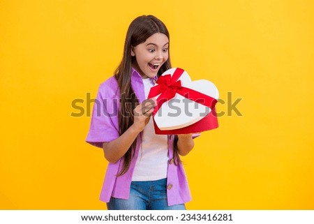 surprised teen girl holding heart box for Valentines Day
