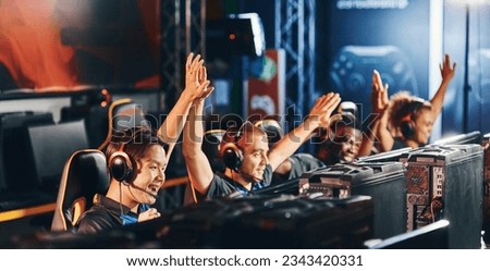 Celebrating success. Team of happy proffesional cyber sport gamers giving high five to each other while participating in eSports tournament Royalty-Free Stock Photo #2343420331