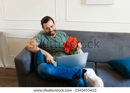 Excited attractive man in a romantic long distance-relationship having a virtual date with his girlfriend on a video call Royalty-Free Stock Photo #2343455423