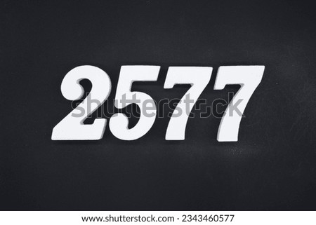 Black for the background. The number 2577 is made of white painted wood.