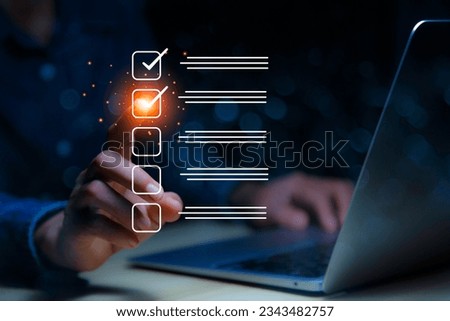 Checklist Online Documentation data Management concept. businessman checking mark on checklist on the check boxes with a red marker on dark background. Royalty-Free Stock Photo #2343482757