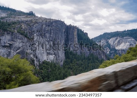 Great vistas of massive granite rock formations seen from scenic roads in Yosemite National Park, California, United States of America, USA. Blurred moving picture while driving the car. Roadtrip