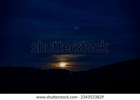 Twilight of the moon behind the mountain