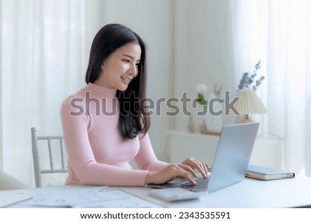 Successful Asian businesswoman smiling using laptop computer at office. Confident Asia businesswoman sitting happily in the office.